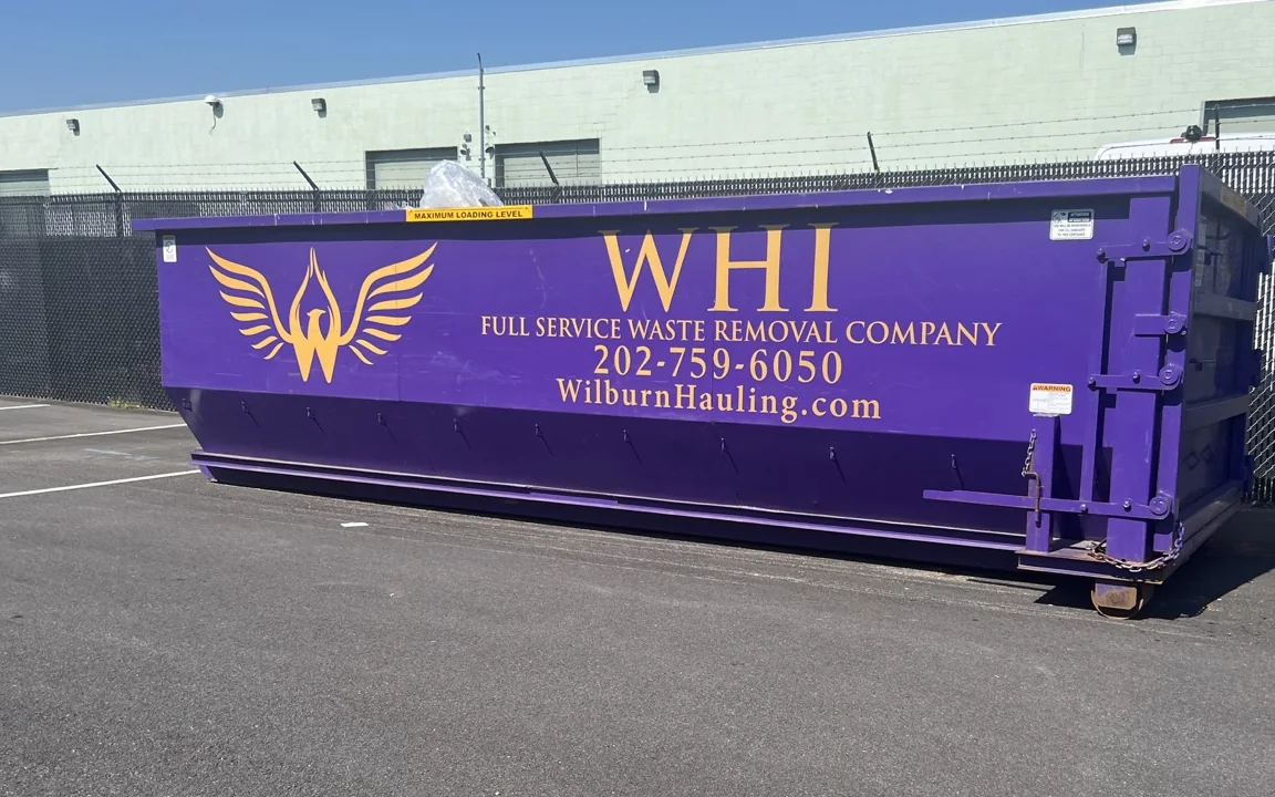 Purple Wilburn Hauling roll-off container with gold company branding
