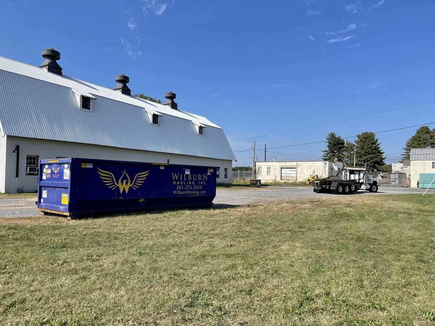 Wilburn Hauling branded container and roll-off equipment in the yard