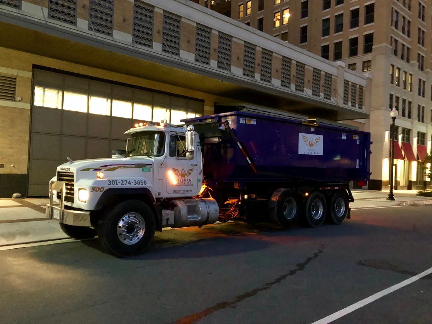 Wilburn Hauling collection truck with a purple body operating at night
